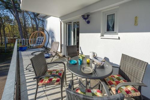 a patio with a table and chairs on a balcony at Fewo Strandallee - Baabe in Baabe