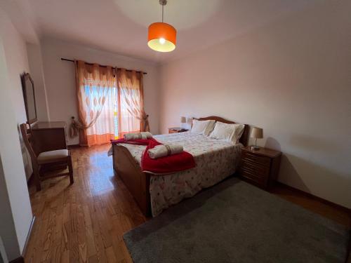 a bedroom with a bed and a chair and a window at Casa do Rodrigo in Mondim de Basto