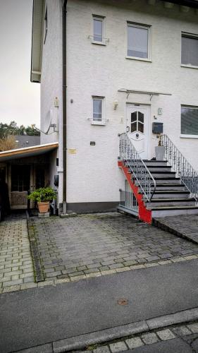 a white building with stairs and a white door at Souterrain Casa Siegburg in Siegburg