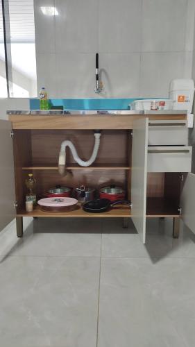 a kitchen counter with a sink and dishes on it at Quarto Casal Com AR Condicionado e Banheiro Privativo in Guaíra