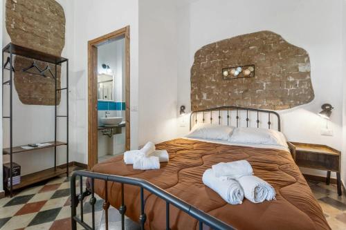 a bedroom with a large bed with towels on it at Luxar Suites & Apartments in Assemini