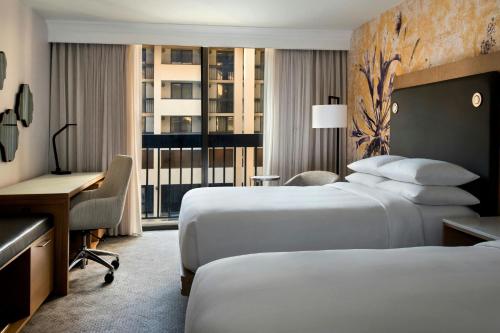 a hotel room with two beds and a desk at Westchester Marriott in Tarrytown
