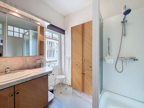 a bathroom with a sink and a shower at Maison No Catiau - De Panne in De Panne