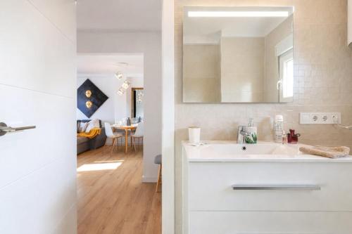 a white bathroom with a sink and a mirror at Amber Signature Apartment in Torrevieja