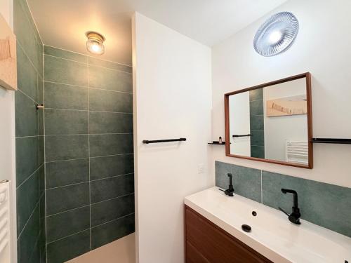 a bathroom with a sink and a mirror and a shower at Les Alizés, 3 étoiles in La Brée-les-Bains
