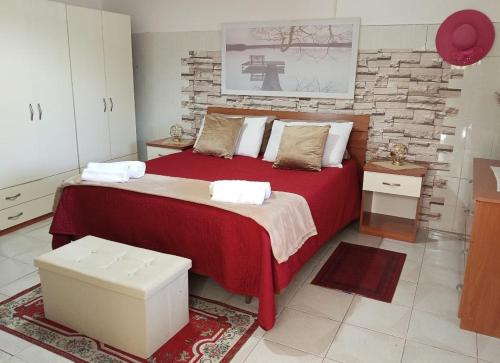 a bedroom with a large bed with red sheets and white pillows at B&B Romy House in Pianopoli