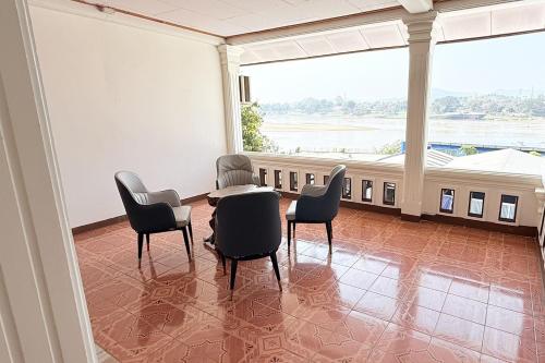 a large room with chairs and a table and a large window at Bokeo Lodge & Restaurant in Ban Houayxay