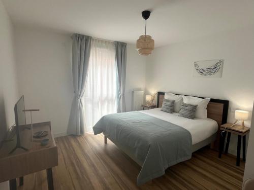 a white bedroom with a bed and a window at DOMITYS - L'Elyme des sables in Neufchâtel-Hardelot