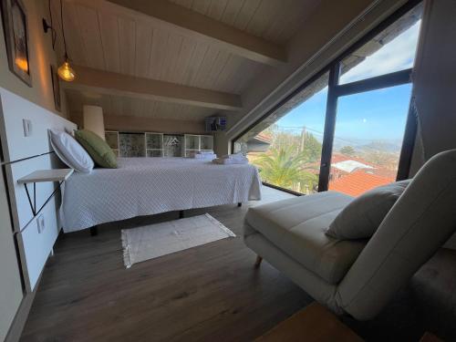 a bedroom with a bed and a couch and a large window at Casa Candida in Samaleo