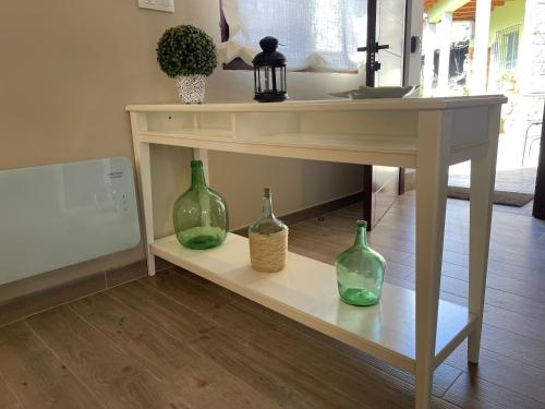 three green glass vases sitting on a table at Casa Candida in Samaleo