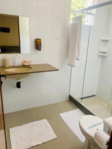 a bathroom with a shower and a sink and a mirror at Elegância Praia da Sereia in Vila Velha