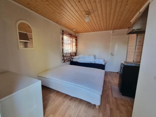 a bedroom with two beds and a wooden ceiling at Narvijärven lomamökki in Rauma