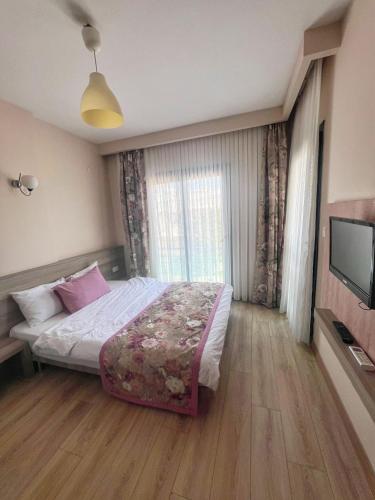 a bedroom with a bed and a flat screen tv at Marina Suite Otel in Silifke