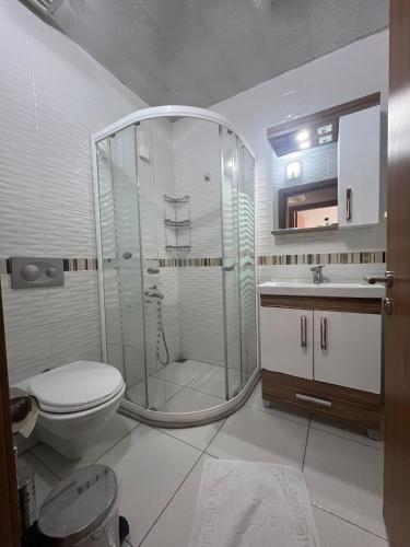 a bathroom with a shower and a toilet and a sink at Marina Suite Otel in Silifke