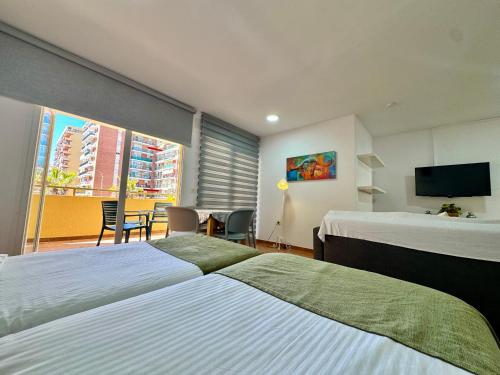 a hotel room with two beds and a television at Apartamentos Turísticos Yamasol in Fuengirola