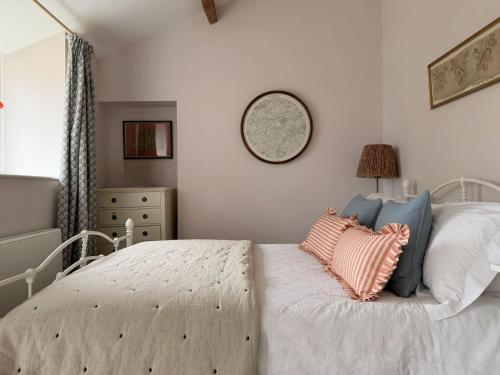 a bedroom with a white bed with pillows on it at The View Cottage - Tennis Court - Nr Frome, Longleat in Frome