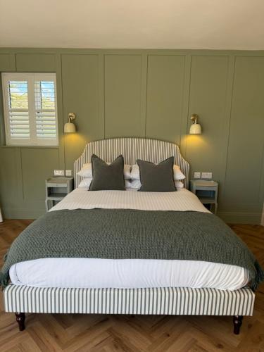 a bedroom with a large bed with two pillows at Lillypool Farm in Shipham