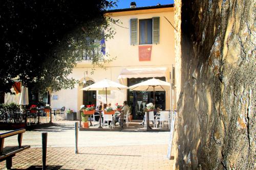 a group of people sitting at tables under umbrellas at Locanda Delle Mura Anna De Croy in Magliano in Toscana