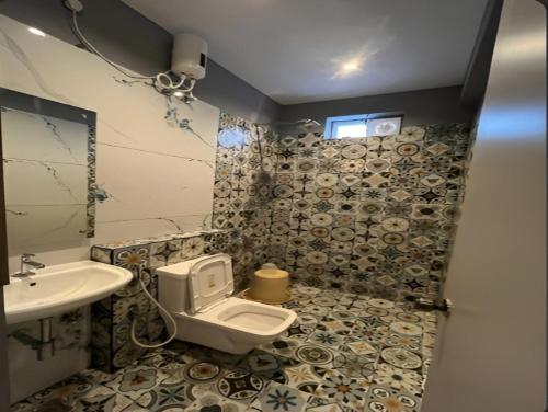 a bathroom with a toilet and a sink at The K Inn Wavefront in Mahabalipuram