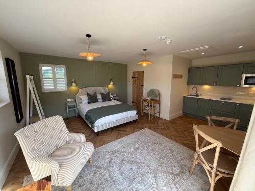 a bedroom with a bed and a table and a kitchen at Lillypool Farm in Shipham
