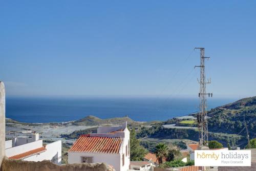 a view of a town with the ocean in the background at Homity Holidays - Gualchos - Casa Río Oculto in Gualchos