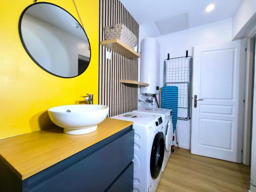 a bathroom with a sink and a washing machine at maison cosy proche du port et plage in Grand-Fort-Philippe