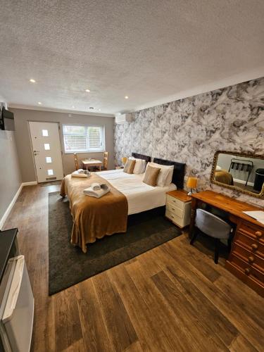 a bedroom with a large bed and a desk at The Golf Studio Woodhall Spa in Woodhall Spa