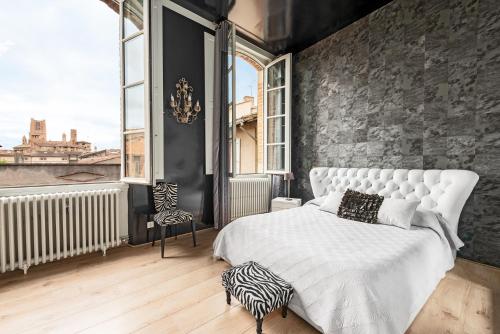 a bedroom with a white bed and a large window at La Rose des Vents Le Vigan - Hyper centre - Parking in Albi