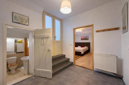 a bathroom with a toilet and a bedroom with a bed at Kovárna Klapý pod Hazmburkem - České středohoří in Klapý