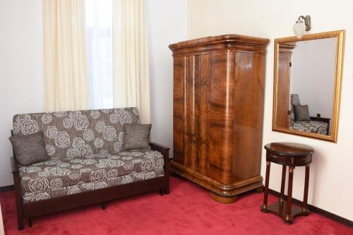 a living room with a couch and a mirror at Guest House Vila Lujza in Palić