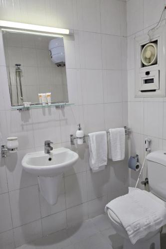 a white bathroom with a sink and a toilet at نادي البحارة الدولي - International Seamans Club in Suez