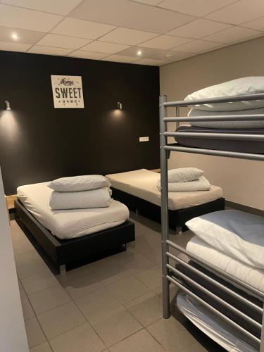 a room with three bunk beds with a sign that says sleep sweet at De Peelrand Hoeve in Venhorst