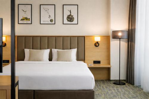 ein Hotelzimmer mit einem Bett und zwei Bildern an der Wand in der Unterkunft B1 City Hotel Sofia in Sofia