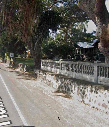 a stone fence on the side of a road at Hale Naalehu LLC Bed and Breakfast in Naalehu