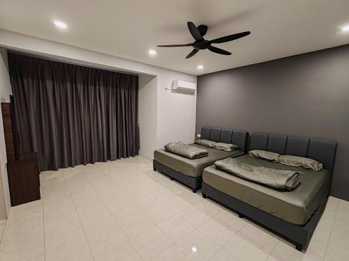a bedroom with two beds and a ceiling fan at ipohbnb Bercham HomeStay in Ipoh