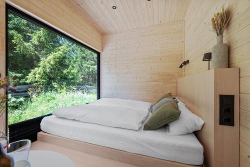 a bed in a small room with a window at Tirol Cabin by ALPAMI in Wildermieming