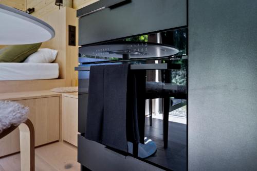 a kitchen with a black stove with a table at Tirol Cabin by ALPAMI in Wildermieming