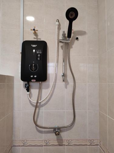 a shower in a bathroom with a camera on the wall at ipohbnb Bercham HomeStay in Ipoh