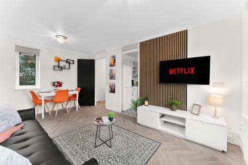 a living room with a couch and a tv on a wall at Centrally Located Apt with Parking in Walsall