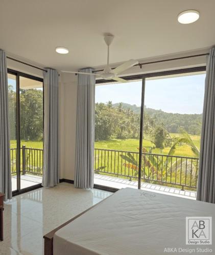 a bedroom with a bed and a large window at The Paddy Breeze Villa in Marukwatura