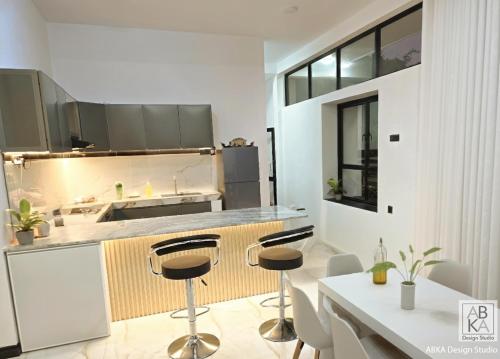 a kitchen with two bar stools and a counter at The Paddy Breeze Villa in Marukwatura