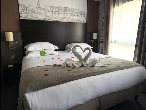 a bed with a couple of towels on it at Holiday Inn Paris Montmartre by IHG in Paris
