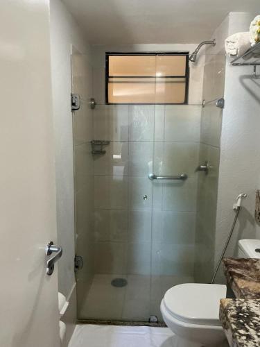 a bathroom with a glass shower with a toilet at Apartamento 1307 QUALITY HOTEL in Natal