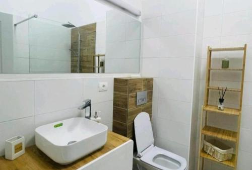 a white bathroom with a sink and a toilet at Stefan Resort Mamaia Nord in Mamaia Sat/Năvodari
