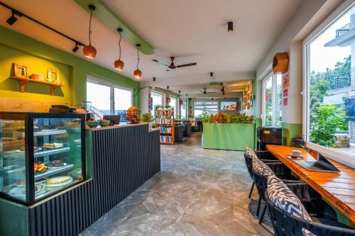 a restaurant with a counter and tables and chairs at PACK Dharamkot in McLeod Ganj