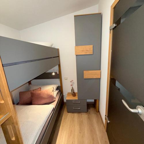 a small bedroom with a bunk bed and a wooden floor at Tiny Haus in Bad Sulza