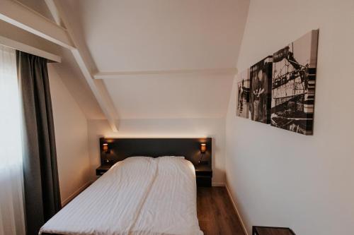 a bedroom with a bed with a black headboard at Hotel Tholen in Tholen