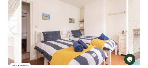 a bedroom with two beds with towels on them at Snowdrop Cottage in Totnes