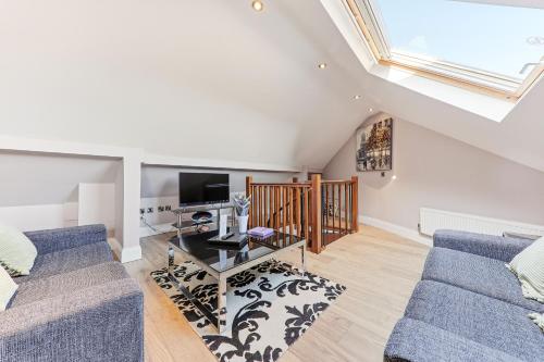 a living room with a blue couch and a tv at Harrogate Lifestyle Apartments Ltd in Harrogate
