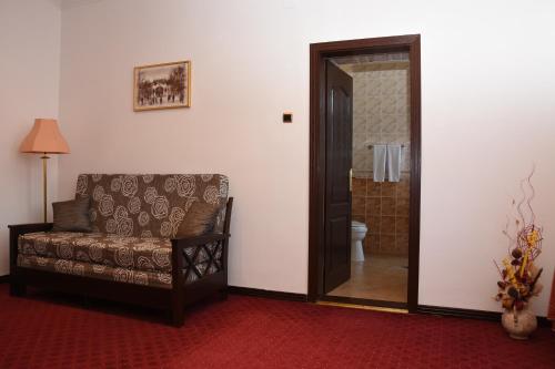 a living room with a couch and a bathroom at Guest House Vila Lujza in Palić